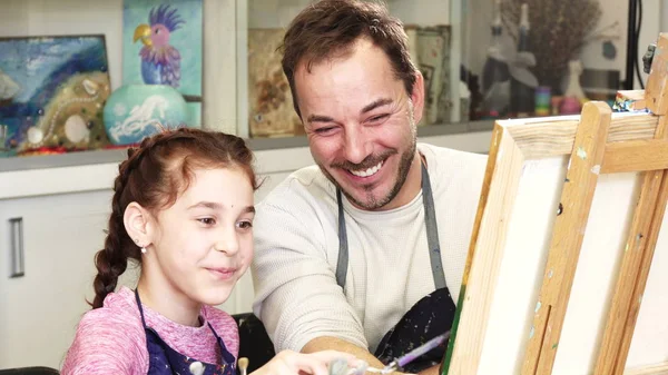 可爱的小女孩和她慈爱的父亲一起画一幅画 成熟英俊的男人享受绘画与他的年轻女儿家庭艺术艺术家生活方式爱创意 — 图库照片