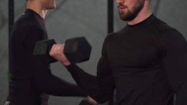 Atış sakallı bir kaslı adamın spor salonunda ağırlık kırpılmış