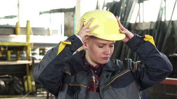 İşten sonra onu kask alarak yorgun kadın fabrika işçisi