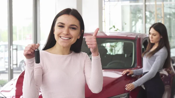 Joven alegre mostrando los pulgares arriba sosteniendo las llaves del coche — Foto de Stock