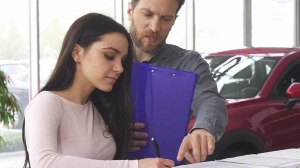 Reifer Autohändler signiert Papiere mit seiner Kundin — Stockfoto