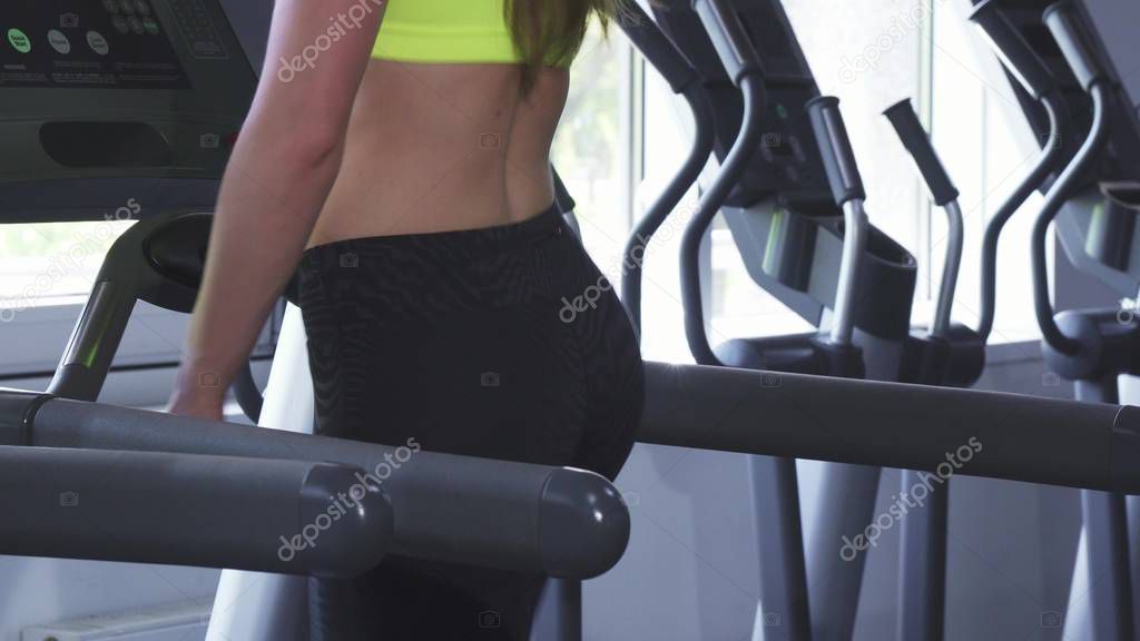 Close up shot of a sexy sportswoman with perfect butt running on a treadmill