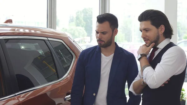 İki erkek arkadaş discuaaing yeni bir araba bayilik salon