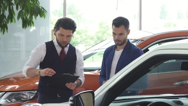 Professioneller Autohändler verkauft Neuwagen an einen jungen Mann — Stockfoto