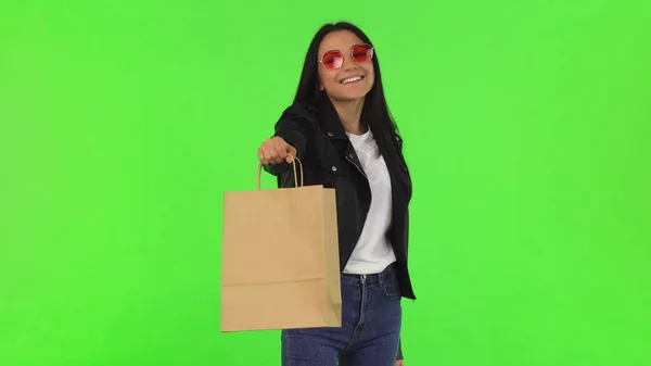 Щаслива красива стильна жінка тримає сумку для покупок у камеру — стокове фото