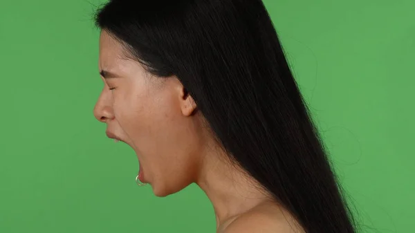 Wunderschöne asiatische deprimierte oder wütende Frau schreit auf Chromakey — Stockfoto