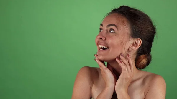 Wanita yang menarik tampak terkejut pada latar belakang kromakey hijau — Stok Foto