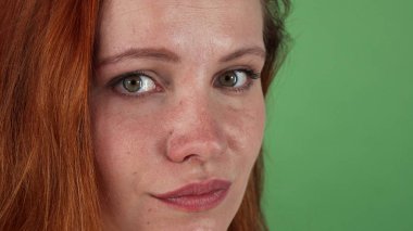 Genç güzel kızıl saçlı kadın kameraya bakıyor