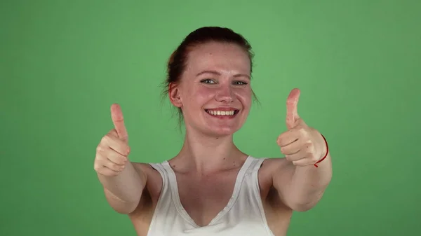 Excitada mulher de cabelos vermelhos sorrindo mostrando polegares para cima — Fotografia de Stock