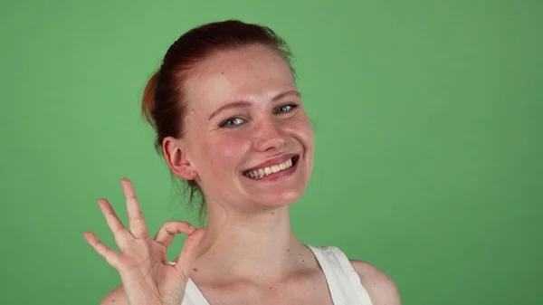Atraente feliz mulher ruiva mostrando sinal ok — Fotografia de Stock