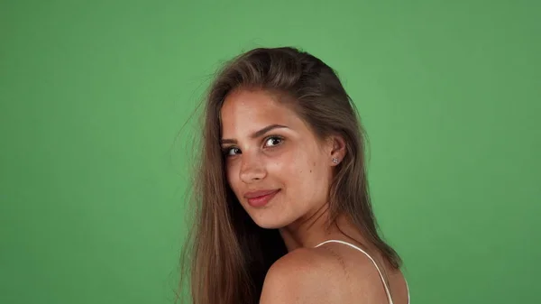 Hermosa joven de pelo largo bronceada mujer sonriendo sobre su hombro —  Fotos de Stock