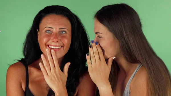 Female friends gossiping on green chromakey background