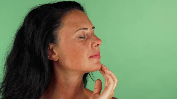 Splendida donna matura con lentiggini sorridente toccando il suo viso — Foto Stock