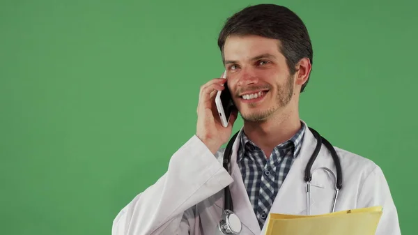 Bearded male doctor talking on the phone looking focused — Stock Photo, Image