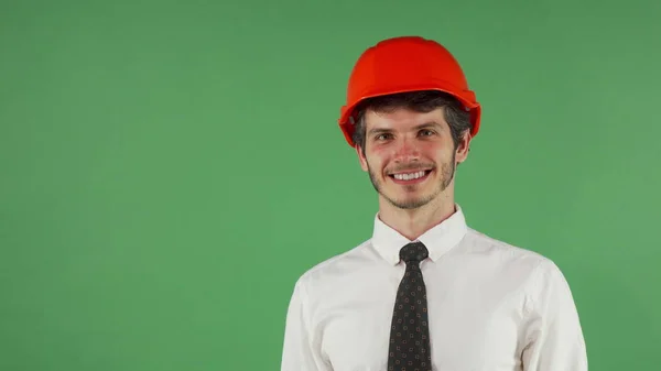 Vrolijke knappe mannelijke ingenieur dragen van veiligheidshelm knipogen naar de camera — Stockfoto