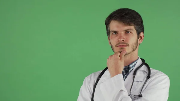 Joven médico varón mirando hacia otro lado pensativamente —  Fotos de Stock