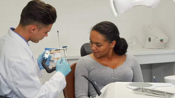 Dentista conversando com sua paciente mostrando seu molde dentário — Fotografia de Stock