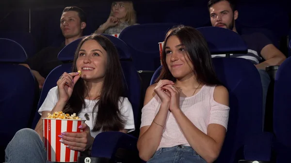 Vackra unga kvinnor som njuter av att titta på filmer på bio — Stockfoto