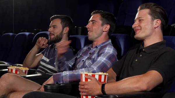 Группа друзей-мужчин, смотрящих фильмы вместе в кинотеатре — стоковое фото
