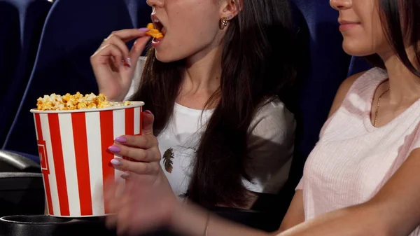 Amigas alegres comendo pipocas no cinema — Fotografia de Stock