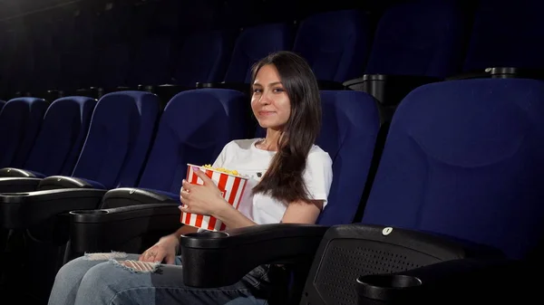 Jovem atraente desfrutando de filmes no cinema — Fotografia de Stock