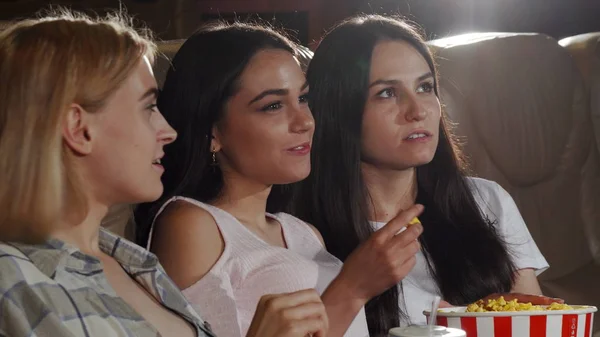 Tre vackra unga kvinnor ler till kameran i biosalongen — Stockfoto
