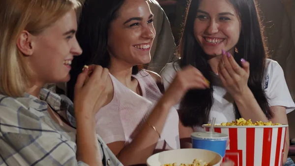 Üç genç kadın arkadaş birlikte bir film izlerken gülmekten