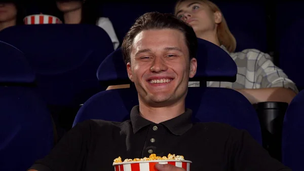 Happy attractive man smiling to the camera at the cinema