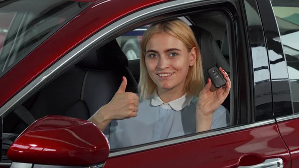 Szczęśliwa kobieta-kierowca przedstawienie jej kluczyki do samochodu i kciuki w górze — Zdjęcie stockowe