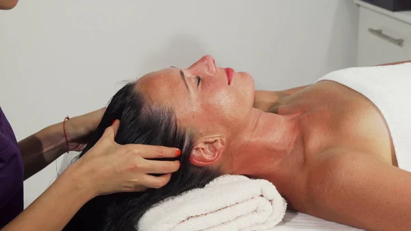 Atractiva mujer madura relajante mientras recibe masaje en la cabeza — Foto de Stock