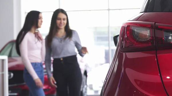 Zwei Frauen diskutieren im Autohaus über ein neues Auto — Stockfoto