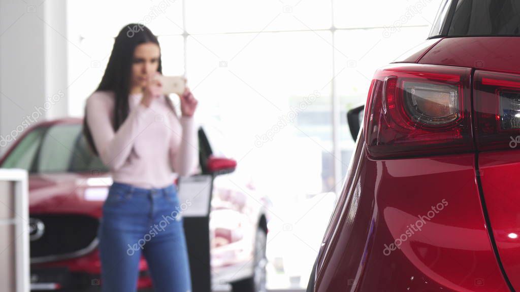 Woman taking photos of a car with her smart phone