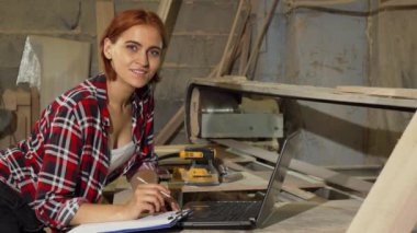 Onun atölyesinde kameraya gülümseyen güzel kadın marangoz