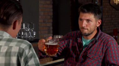 Olgun sakallı adam barda bira yudumlarken onun arkadaşına söz