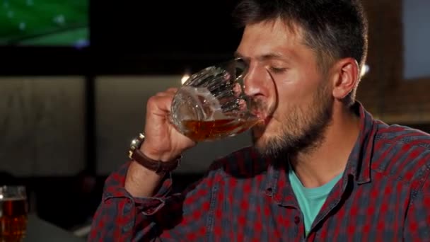 Hombre maduro sonriendo a la cámara mientras bebe cerveza — Vídeos de Stock