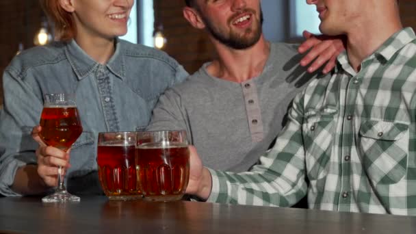 Groep vrienden roosteren en het drinken van bier in de kroeg — Stockvideo