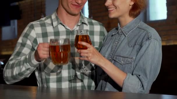 Прекрасная пара обнимается за бокалом пива в ресторане — стоковое видео