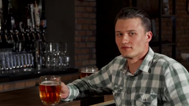 Hezký šťastný muž s úsměvem, opékání svou sklenici piva k fotoaparátu — Stock video