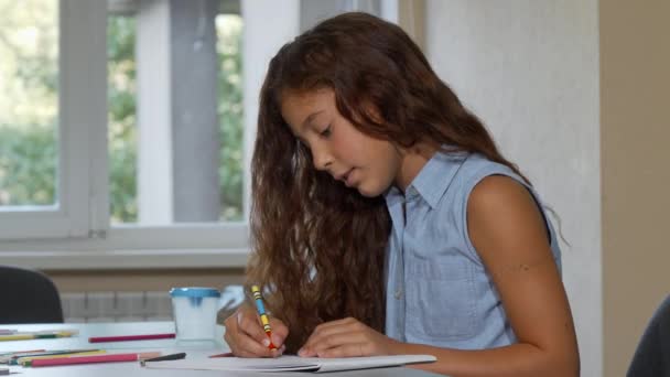 Ładna, młoda dziewczyna, patrząc od hotelu sennie, podczas rysowania w szkole — Wideo stockowe