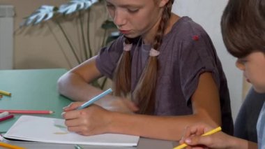 Genç kız ve erkek birlikte sınıfta çizim