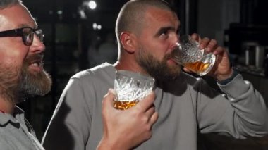 Yakışıklı adam ve arkadaşı viski bar futbol maçında izlerken