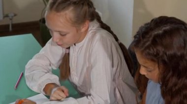 İki küçük kız öğrenciler birlikte sanat dersinde boyama