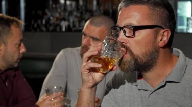 Lezzetli viski tadımı sonra kameraya gülümseyen sakallı olgun adam