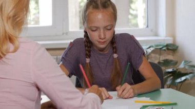 Öğretmen yardımıyla onun sanat proje üzerinde şirin kırmızı saçlı kız öğrenci