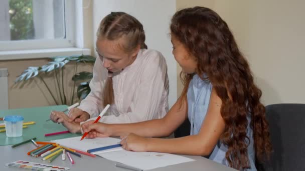 Två skolkamrater prata medan du ritar tillsammans på konst klass lektion — Stockvideo