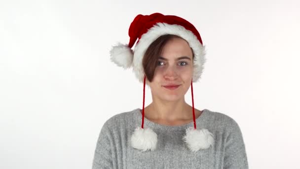 Menina feliz bonita usando chapéu de Natal, sorrindo alegremente para a câmera — Vídeo de Stock