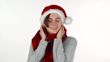 Mutlu kadın Noel şapka ve kış eşarp kameraya gülümseyen.