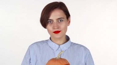 Kadın yüzüne oyulmuş Cadılar Bayramı Balkabağı arkasında saklanıyor