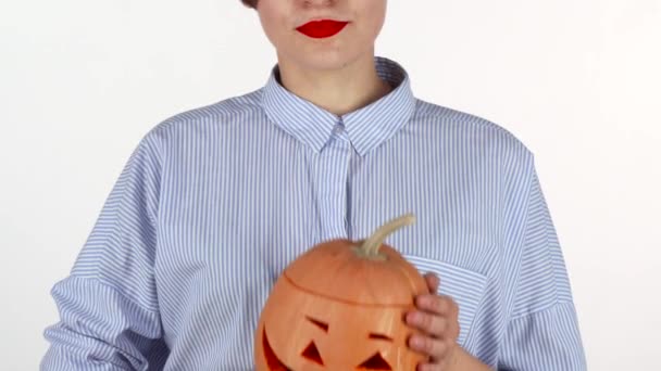 Femme portant rouge à lèvres tenant debout sculpté citrouille d'Halloween — Video