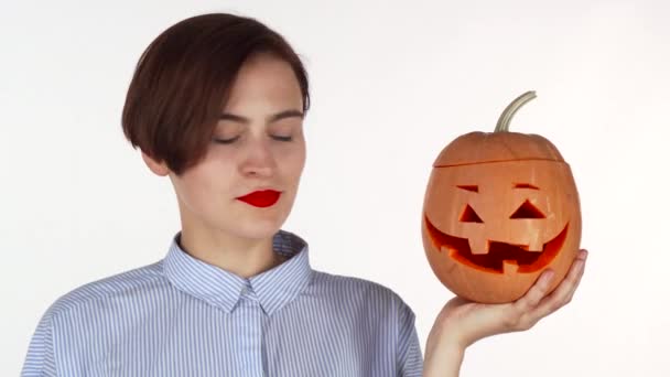 Belle femme souriant à la caméra, tenant halloween citrouille sculptée — Video